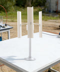 Three Blade Vertical Axis Wind Turbine Kit With 12V 40W 3-Phase Permanent Magnet Motor on a table, outdoor setting