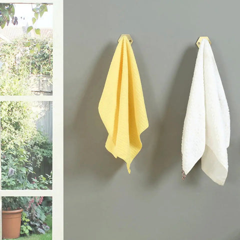 Top Shelf Brass Wall Hooks For Towels And Mugs No Sweat Rust Proof Bathroom Hanger holding yellow and white towels on gray wall.
