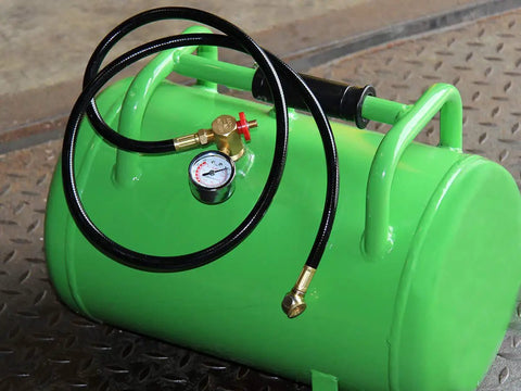 Green air tank assembly kit with 4 ft air hose and 1/4 in NPT tire chuck, brass manifold, 0-200 PSI gauge on a metal surface.