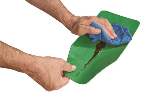 Flexible Shapeable Funnel For Any Job, Reusable Silicone Pouring Tool being wiped clean while flattened, showing green material.