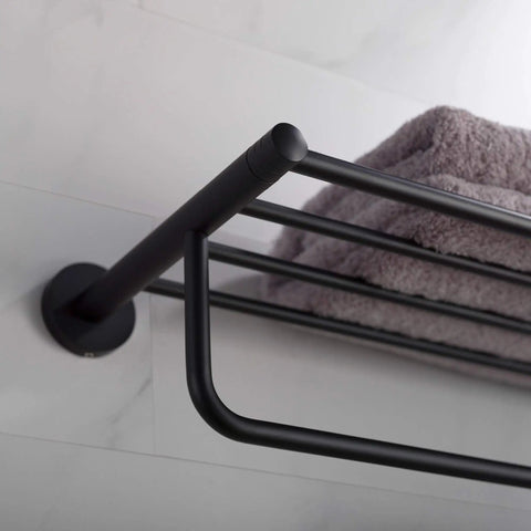 Close-up of Elie Matte Black Bathroom Shelf With Towel Bar Built Tough From Solid Brass, mounted on a bathroom wall with gray towel.