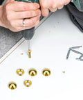 Person using a drill to install Top Shelf Vintage Style Brass Screws With Flush Caps on wooden project, showing 15mm screws.