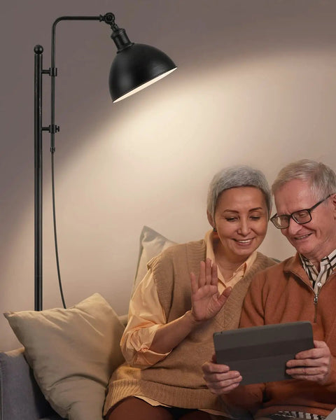 Couple using tablet under Industrial Floor Lamp With Adjustable Height And Rotating Head, Rustic Aged Black Farmhouse Metal Floor Lamp