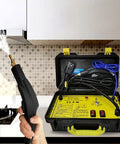 Handheld steam cleaner in use, emitting steam in kitchen, with open case and cables visible. Powerful 3200W Handheld Steam Cleaner With 5 Bar Pressure And 229 F Steam In 10 Seconds Beat Stubborn Grime Fast For Home And Auto Cleaning Ideal For Air Conditioners Range Hoods Cars And Grimy Surfaces Compact With Built In Water Hose.