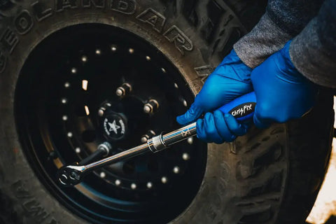 Mechanic using Three Piece Extendable Ratchet Set With Half Inch Drive, Three Eighths Inch Drive, And Quarter Inch Drive on car wheel