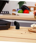 Black silicone diverter hose for pressure cookers on wooden kitchen counter, demonstrating use and size