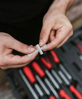 Close-up of hands holding Mini Cross Socket Wrench Kit M2 M2.5 M3 for RC Model Cars, silver alloy material.
