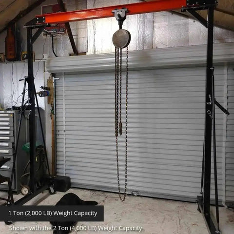 Bad Boy Heavy Weight One Ton Gantry Crane Frame Rated For Two Thousand Pounds adjustable hoist rig with pulley in workshop setting.