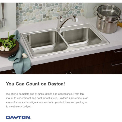 Double bowl stainless steel kitchen sink with faucet installed in modern countertop with vegetables and pot nearby.