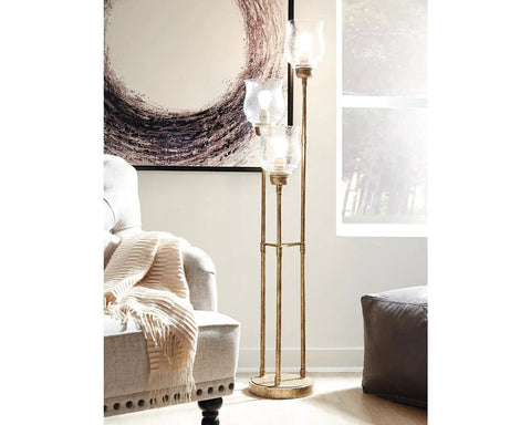 Emmie Traditional Floor Lamp With Adjustable Heights, Three Glass Shades, Antique Gold Finish beside a couch in living room