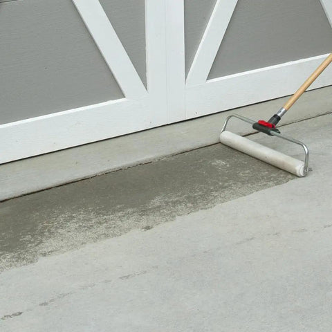 Applying Heavy Duty Clear Acrylic Concrete Sealer For Driveways And Patios Fast Drying Waterproof Sealant For Stone And Exposed Aggregate Surfaces 4.75 Gallon Jug Size with a roller.
