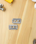 Stainless Steel Towel Bar Mounting Hardware Set With 45x26mm Backing Plates, screws, and tools on wooden surface