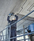 Worker using 5 Inch Diamond Cup Grinding Wheel For Concrete With Double Row Segments on ceiling, dust reducing design in action.