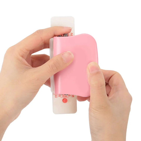 Hands holding a Six Hole Punch For Loose Leaf Paper A4 A5 B5 Portable Handheld Metal Circle Puncher 5 Sheet Capacity Pink