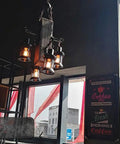 Industrial Vintage Wooden Hanging Pendant Light With Four Lantern Bulbs over a coffee shop window with coffee signs