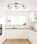 Cedrick 3 Light Track Lighting in Brushed Nickel, adjustable heads, vintage Edison bulbs, installed in modern white kitchen