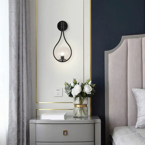Industrial Vintage Matte Black Globe Wall Sconce Set of 2 With Clear Hand Blown Glass Shades in a modern bedroom setting