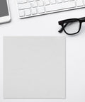 Straight Up Spotless With This Reusable Eyeglass Cleaning Cloth Nano Dust Free Microfiber Wiper For Glasses Computer Screens Laptops And Optical Gear on a desk with glasses.