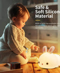 Child playing with Lit Cute Bunny Night Light For Kids With 16 Colors Tap Control Dimmable Lamp, safe silicone, on wooden floor