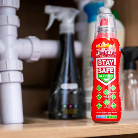 StaySafe All In One Portable Fire Extinguisher That Handles Ten Types Of Fires From Electrical And Kitchen Oils To Lithium Battery Blazes With A Non Toxic Eco Friendly Formula For Home Car And On The Go on a shelf with cleaning products.