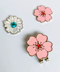 Magnetic Golf Ball Marker Set With Flower Crystal Markers And Hat Clip showing a pink flower and blue crystal markers on a white background.