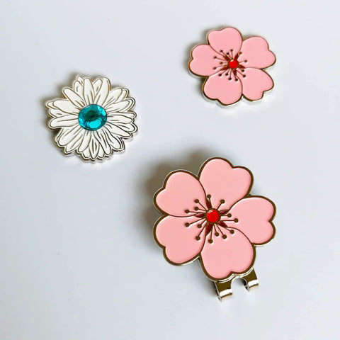 Magnetic Golf Ball Marker Set With Flower Crystal Markers And Hat Clip showing a pink flower and blue crystal markers on a white background.