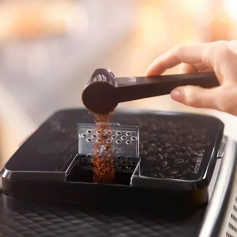 Top Shelf Automatic Espresso Brewer With Sturdy Built In Bean Mill And Silky Milk Frother For Killer Morning Brews No Hassle Auto Clean Features Plus Bold Flavor Dials For Real Coffee Heads Everyday, pouring ground coffee.