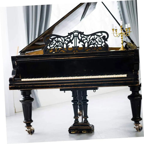 Antique black grand piano with ornate music rest and swivel casters, showcased in a bright indoor setting.