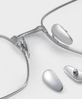 Premium Screw On Titanium Glasses Nose Pads No Sweat Anti Slip Bridge Piece That Absolutely Stays Put Ergonomic Shape Keeps Frames Snug All Day Silver Two Pack Includes Quick Install Tool, close-up view of nose pads and glasses.