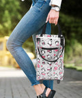 Person holding collapsible trolley bag with wheels for groceries, featuring cartoon pattern, foldable and waterproof Oxford fabric design