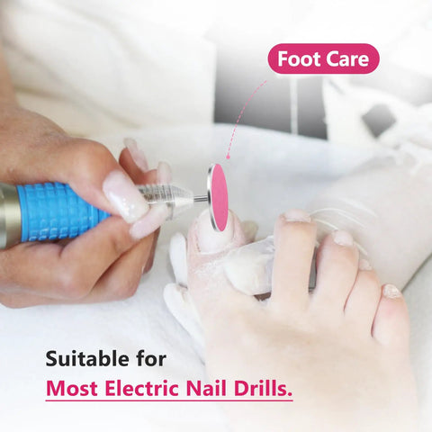 Close-up of sanding paper disc set with metal nail drill bit in use for foot care, showing pedicure process.