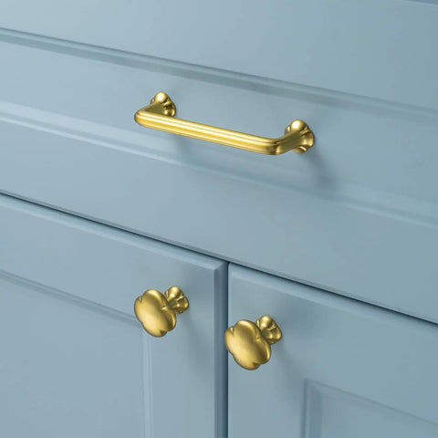 Brushed Gold Cabinet Pulls 10 Pack 3.75 Inch Hole Centers Heavy Duty Metal Handles With Easy Install Screws For Cabinets Drawers Dressers Closets And Vanities Rust Resistant Clover Design installed on blue cabinet