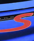 Red S Logo Emblem For Porsche Tailgate Badge on blue car, compatible with 911, 991, 992, 718, Cayenne, Panamera, Macan, Boxster, Turbo, Taycan.