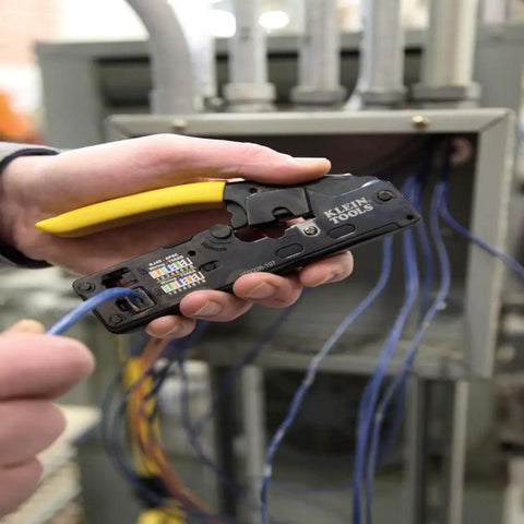 Person using compact ratcheting modular crimper from ProTech Data Kit For Twisted Pair Cabling on wiring panel.