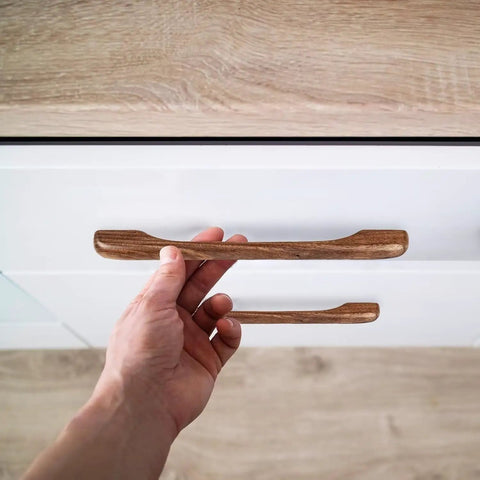 Hand installing Six Piece Walnut Wood Drawer Pulls Ergonomic Cupboard Handles For Kitchen Cabinets And Dressers Minimalist Solid Wood Hardware Easy DIY Replacement For Wardrobes on white drawer