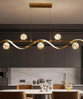 Modern Linear Pendant Light Set Featuring Six Glass Globe Shades Dimmable Gold Kitchen Island Fixture above a dining table.