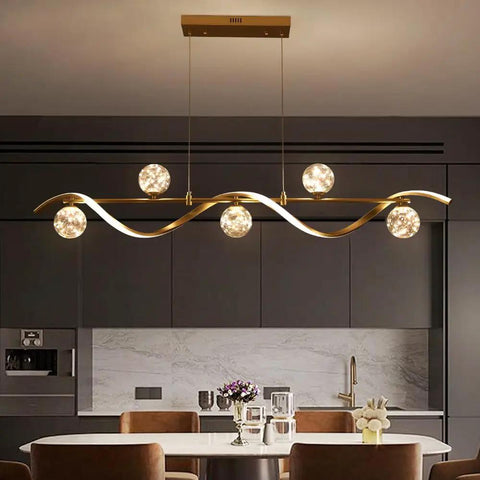 Modern Linear Pendant Light Set Featuring Six Glass Globe Shades Dimmable Gold Kitchen Island Fixture above a dining table.