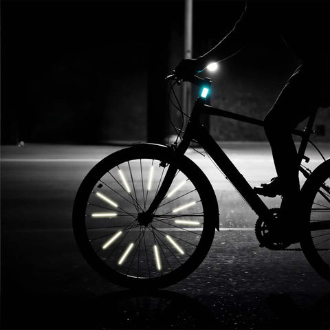 Cyclist riding at night with Reflective Spoke Covers 84 Pack For Bikes And Motorcycles, 80mm Spoke Skins Reflectors on wheels.
