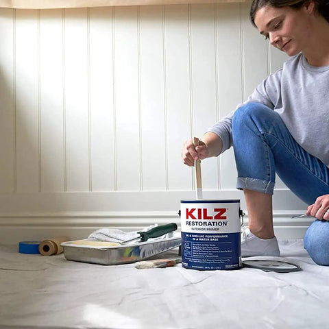 Person preparing to paint with Restoration Primer Interior Sealer And Stainblocker, Water Based, Odor Blocking, 1 Gallon can.