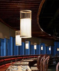 YAXDQUW Modern Style Bamboo Pendant Light Handcrafted Hanging Ceiling Lamp Adjustable Suspension Chandelier E27 Base Vintage Dining Tea Room Light Fixture for Entryway Kitchen Sink Table Living Room in restaurant setting.