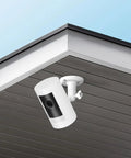 2 Pack No Drill Camera Wall Mount Bracket For Ring And Wyze Security Cameras installed on a ceiling for outdoor surveillance use.