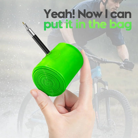 Close-up of neon-green TPU inner tube rolled up with a Presta valve for 29-inch MTB tires