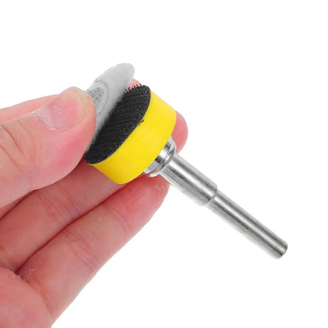 Hand holding a sanding disc tool with yellow backing, compatible with Get Your Hands On This Awesome Set Of 100pcs Sanding Discs With Grits From 100 To 3000 For Smooth Drilling And Shiny Finishes That Last.