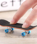 Mini Finger Skateboard With Maple Wood Deck, Deep Concave And High Kick, shown on a table with blue wheels.