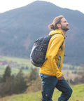 Person hiking with Ultralight 30L Packable Hiking Backpack For Women And Men Foldable Travel Daypack, mountain backdrop.