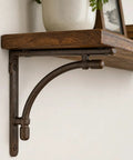 Heavy Duty Industrial Cast Iron Shelf Bracket Set With Bent Pipe Design Brown Matte Finish mounted under wooden shelf