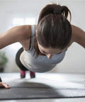 Woman doing push-ups wearing 2 Pack Wrist Wraps For Carpal Tunnel Relief And Pain Prevention, Flexible Adjustable Wrist Brace For Men And Women