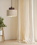 Modern Mini Pendant Light, Travertine Stone Light Fixture with Wooden Accent hanging above a plant and curtains in a bright room.