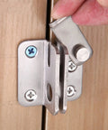 Close-up of a Stainless Steel Spring Latch Lock Bolt Door Gate Cabinet Furniture Hardware being installed on a wooden door.