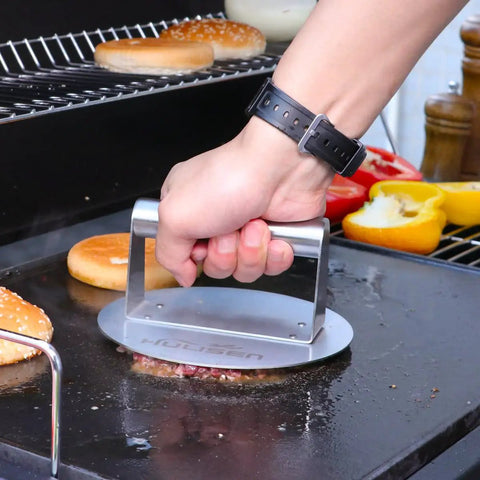 Stainless Steel Burger Press Round 6.2 Inch Smasher For Flat Top Griddles And Grills pressing a patty on the grill